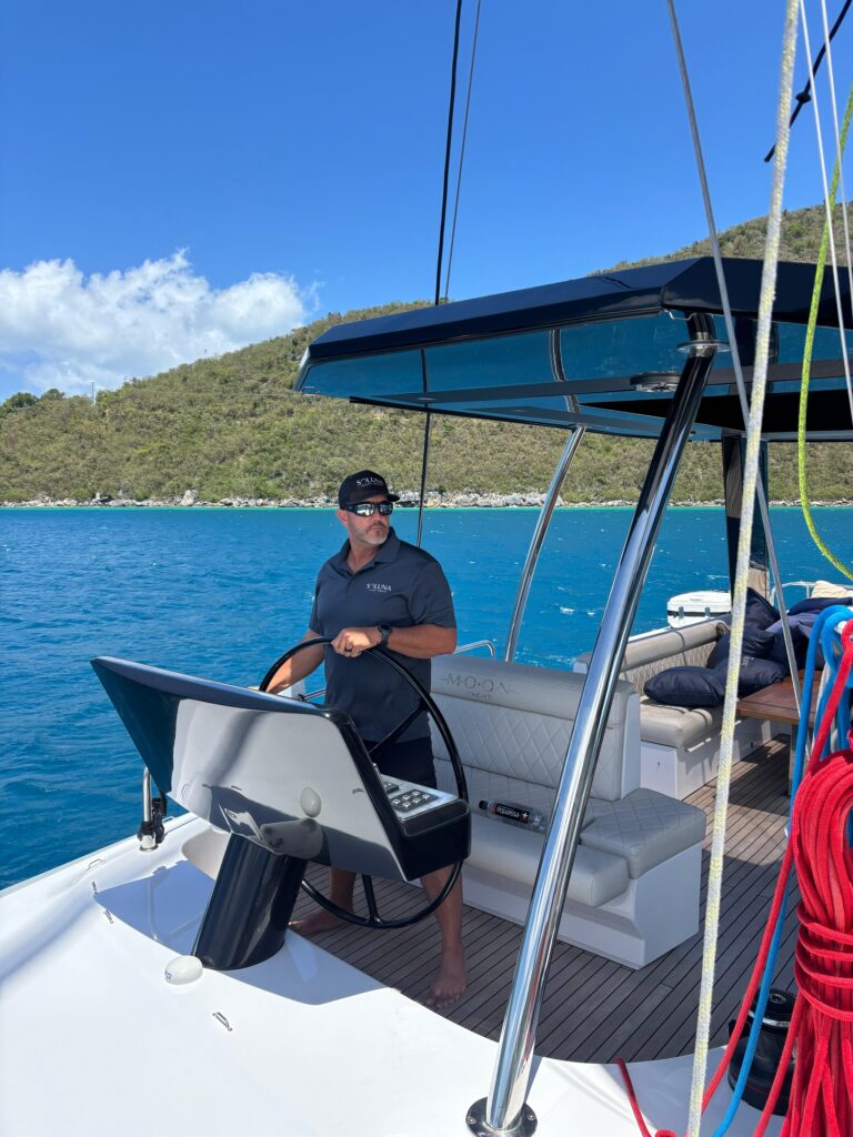 Soluna team member at the helm of a catamaran in the Virgin Islands