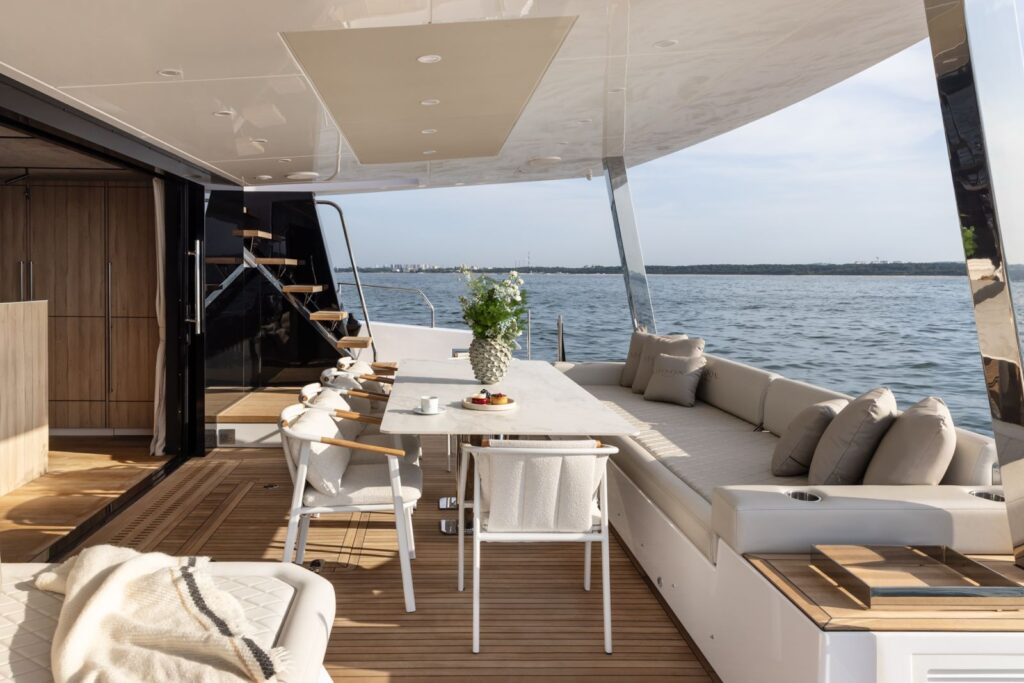 Aft cockpit of Arctic Moon with dining table, lounge seating and steps to the flybridge