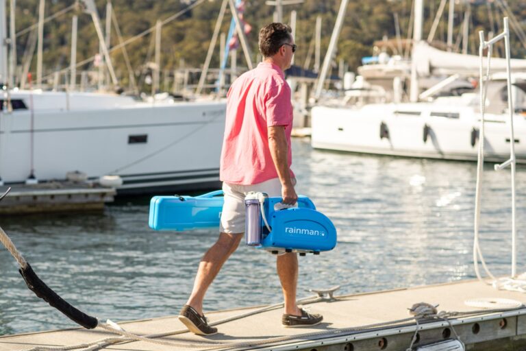 Rainman portable watermaker being carried along a marina pontoon